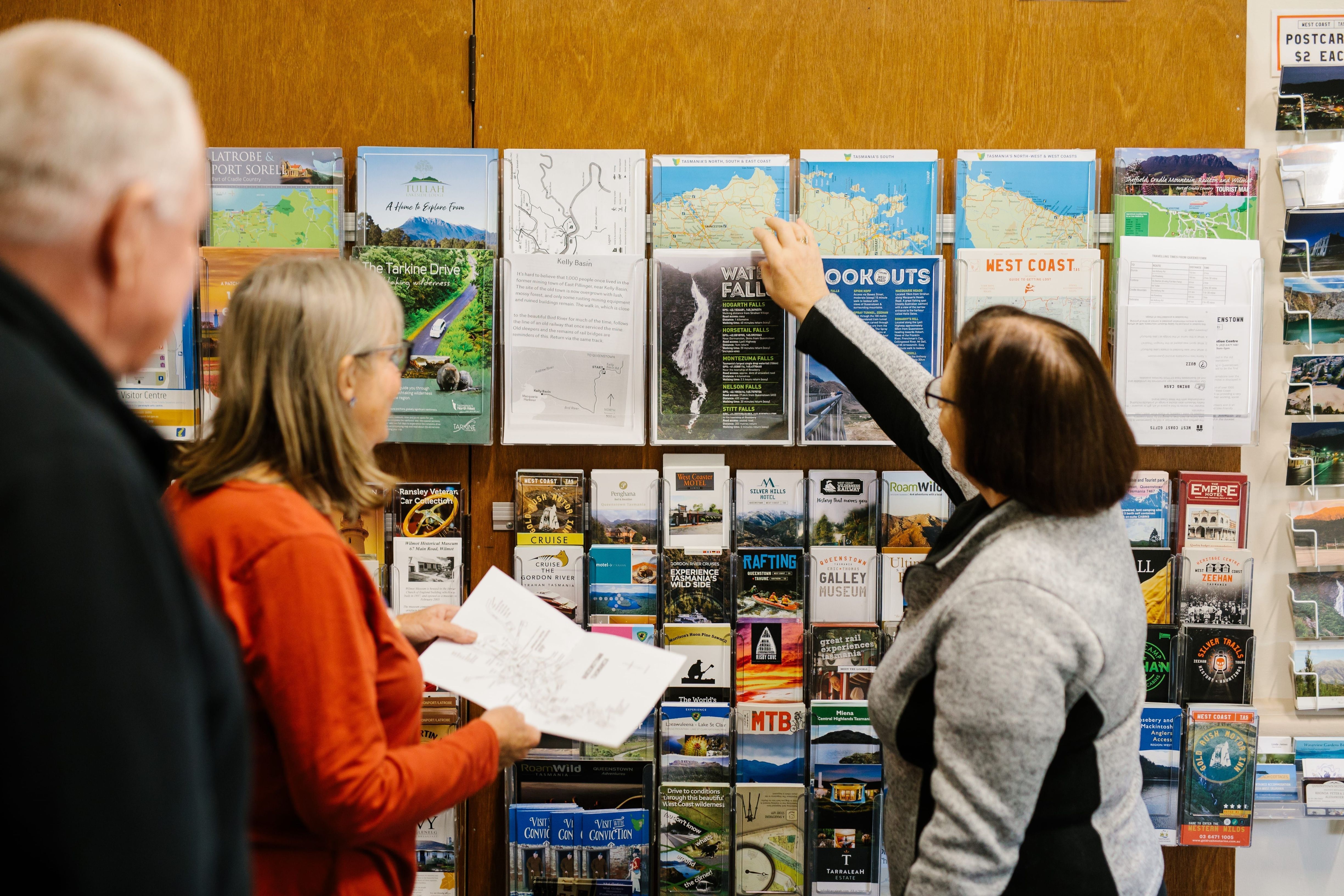 Staff member helping travellers at the brochure rack, Eric Thomas Galley Museum in Queenstown, Tasmania