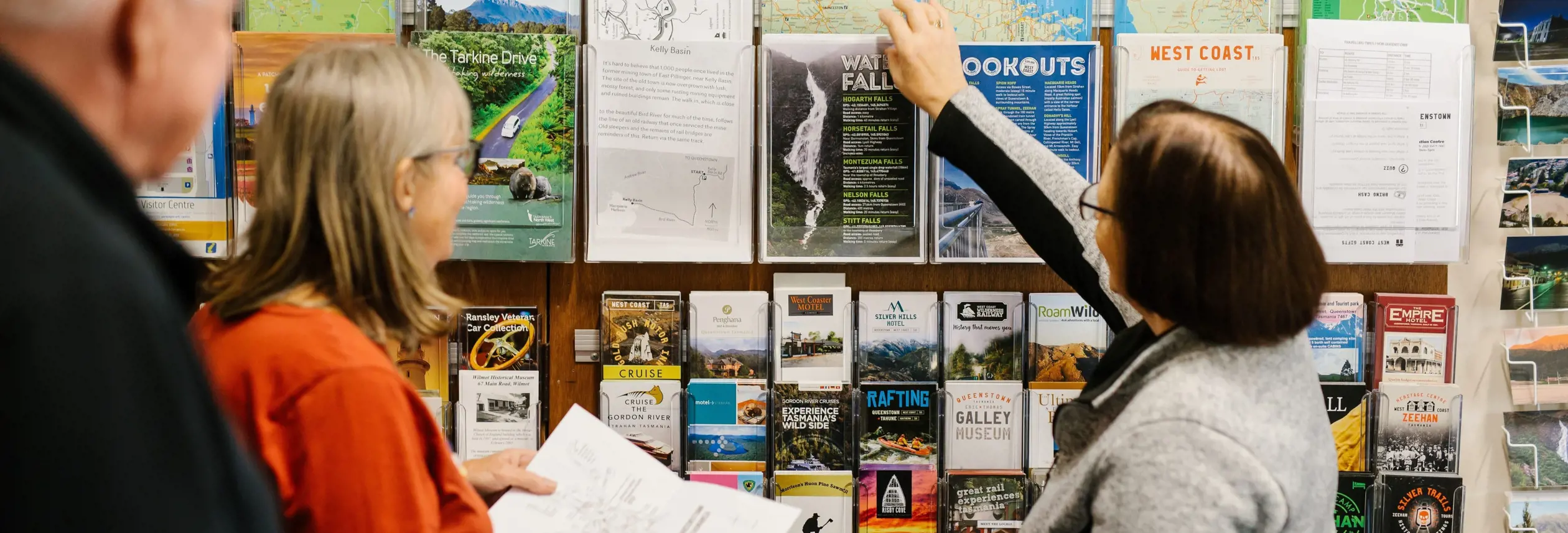 Staff member helping travellers at the brochure rack, Eric Thomas Galley Museum in Queenstown, Tasmania