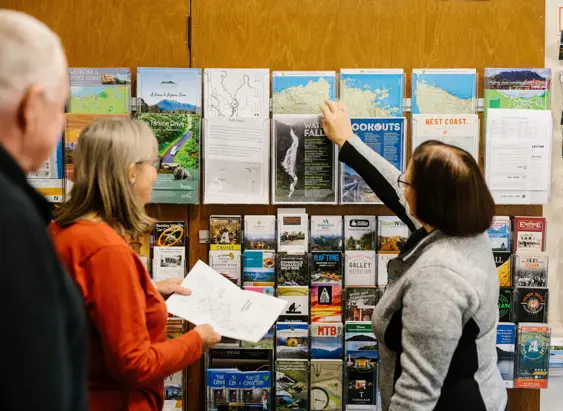 Staff member helping travellers at the brochure rack, Eric Thomas Galley Museum in Queenstown, Tasmania