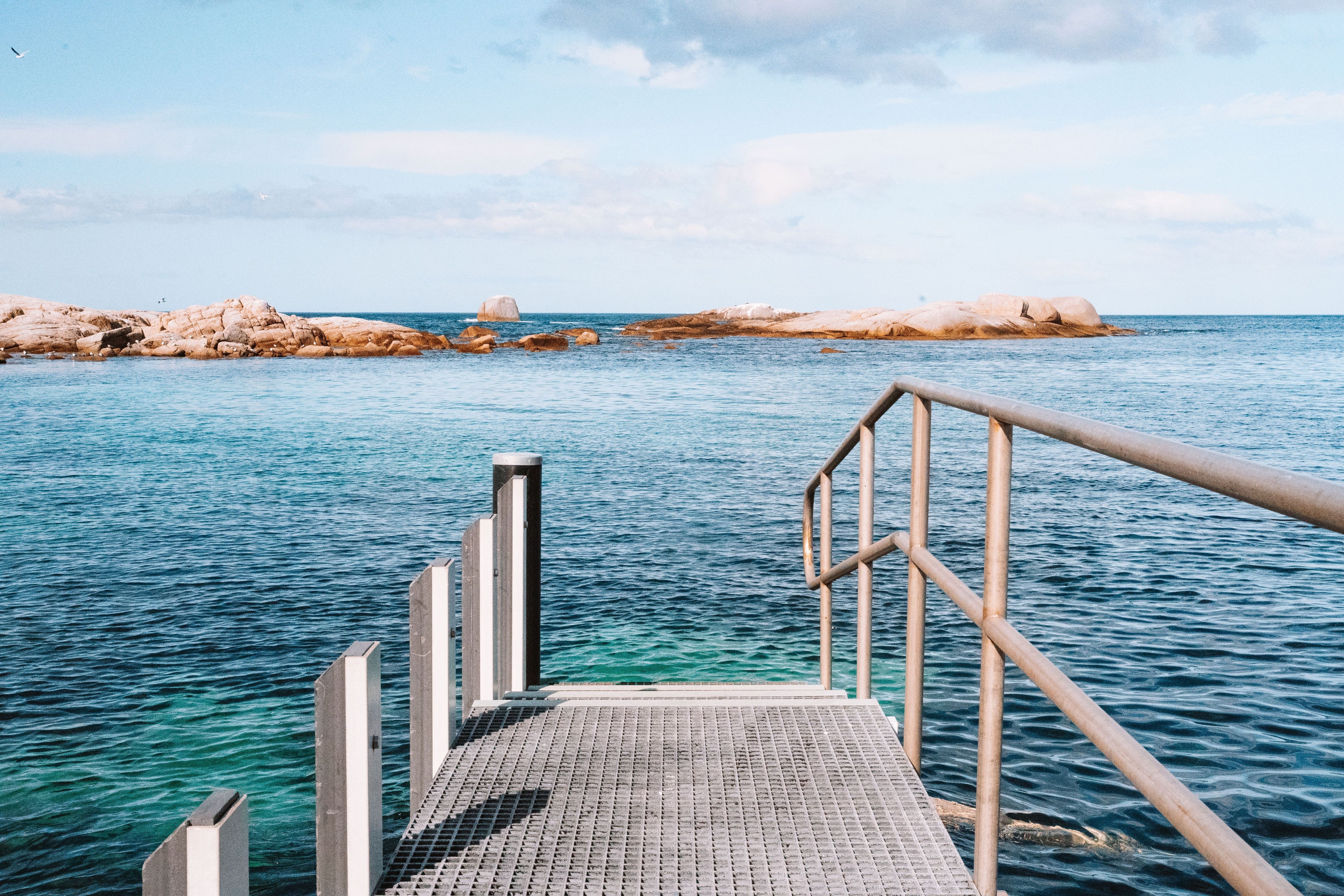 View from a jetty looking out across calm water toward granite outcrops, Coles Bay on Tasmania's East Coast