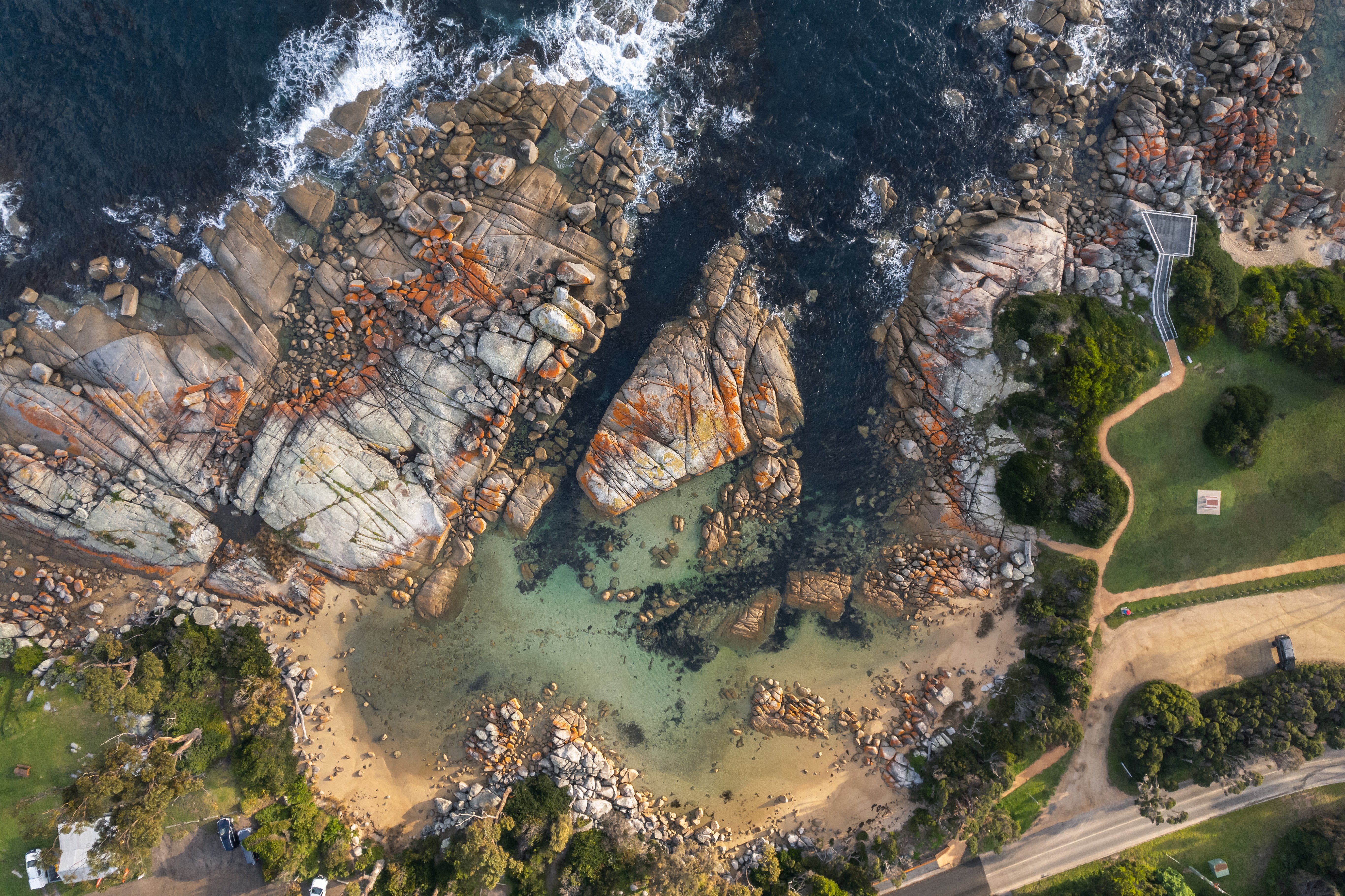 Aerial view of a sandy cove and granite boulders at The Gardens, larapuna / Bay of Fires area, Tasmania's East Coast