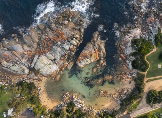 Aerial view of a sandy cove and granite boulders at The Gardens, larapuna / Bay of Fires area, Tasmania's East Coast