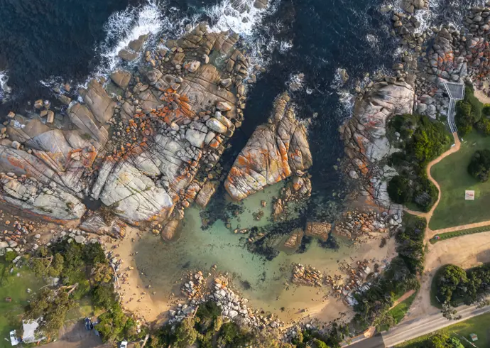 Aerial view of a sandy cove and granite boulders at The Gardens, larapuna / Bay of Fires area, Tasmania's East Coast