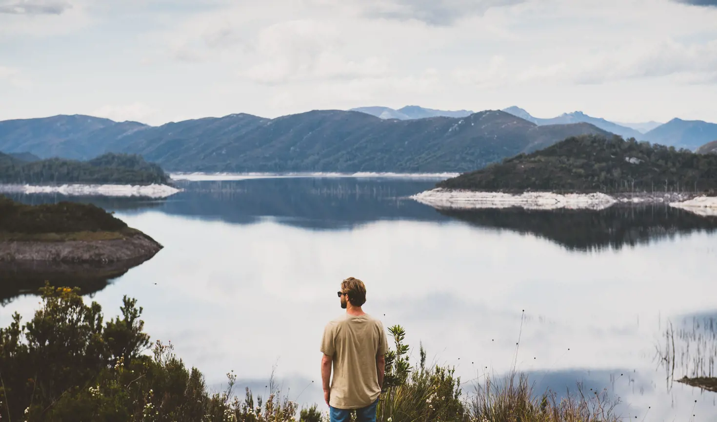 A person looking out over Lake Gordon with mountains in the distance, Strathgordon, Southwest National Park, Tasmania