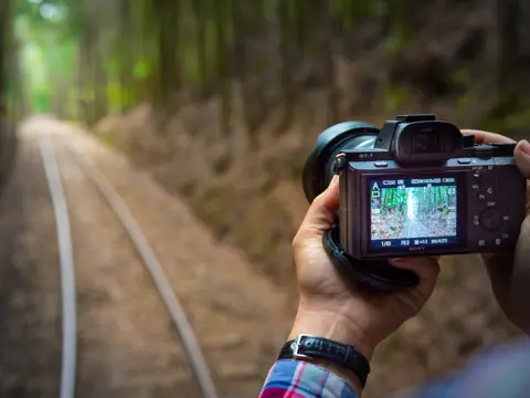 A photographer capturing the West Coast Wilderness Railway track between Queenstown and Strahan, Tasmania