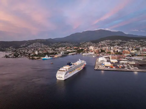 Aerial view of cruise ship Norwegian Sun arriving at Hobart Port with kunanyi / Mount Wellington in the background, Tasmania