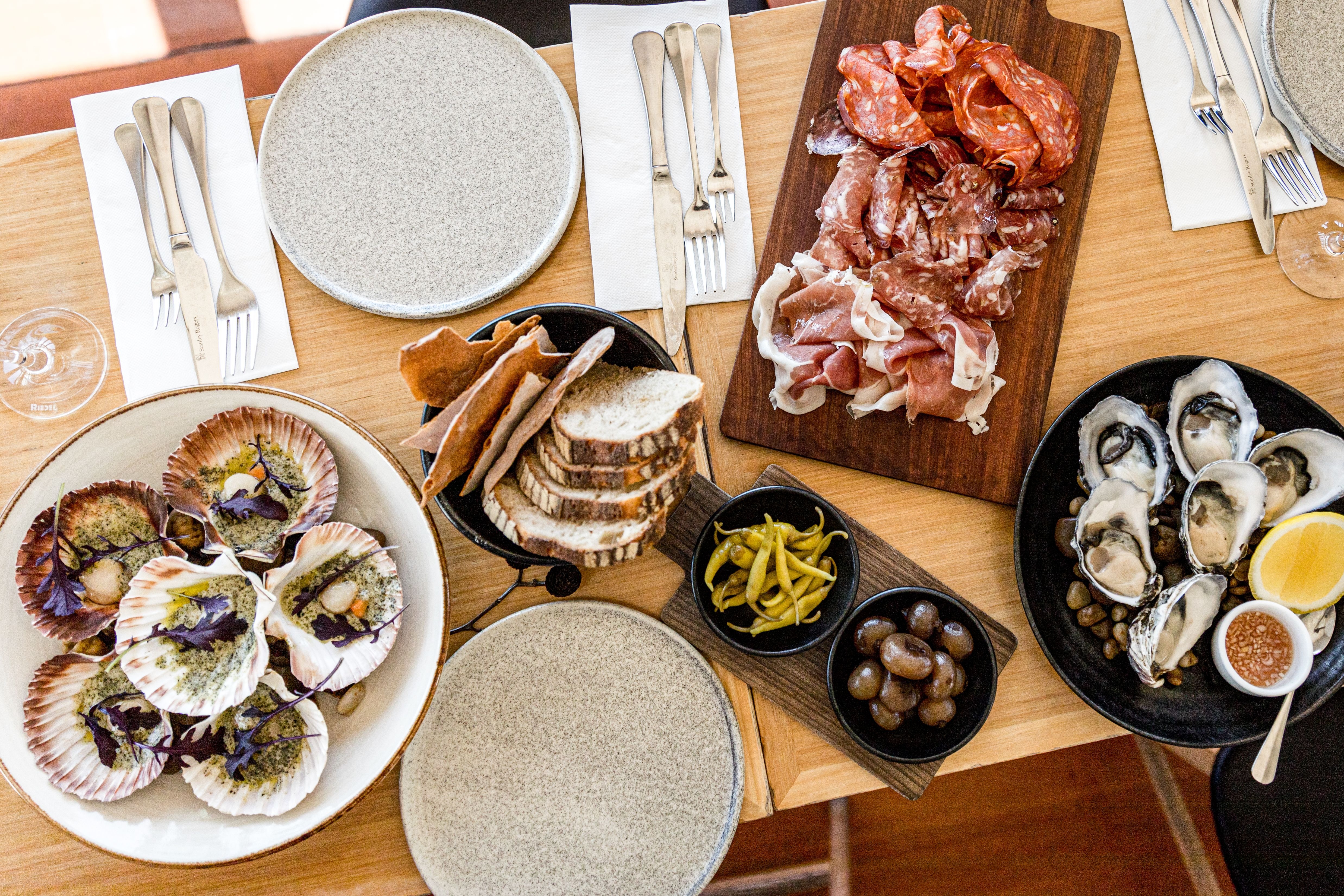 A shared table spread of oysters, charcuterie, bread and shared dishes at Stillwater, Launceston, Tasmania