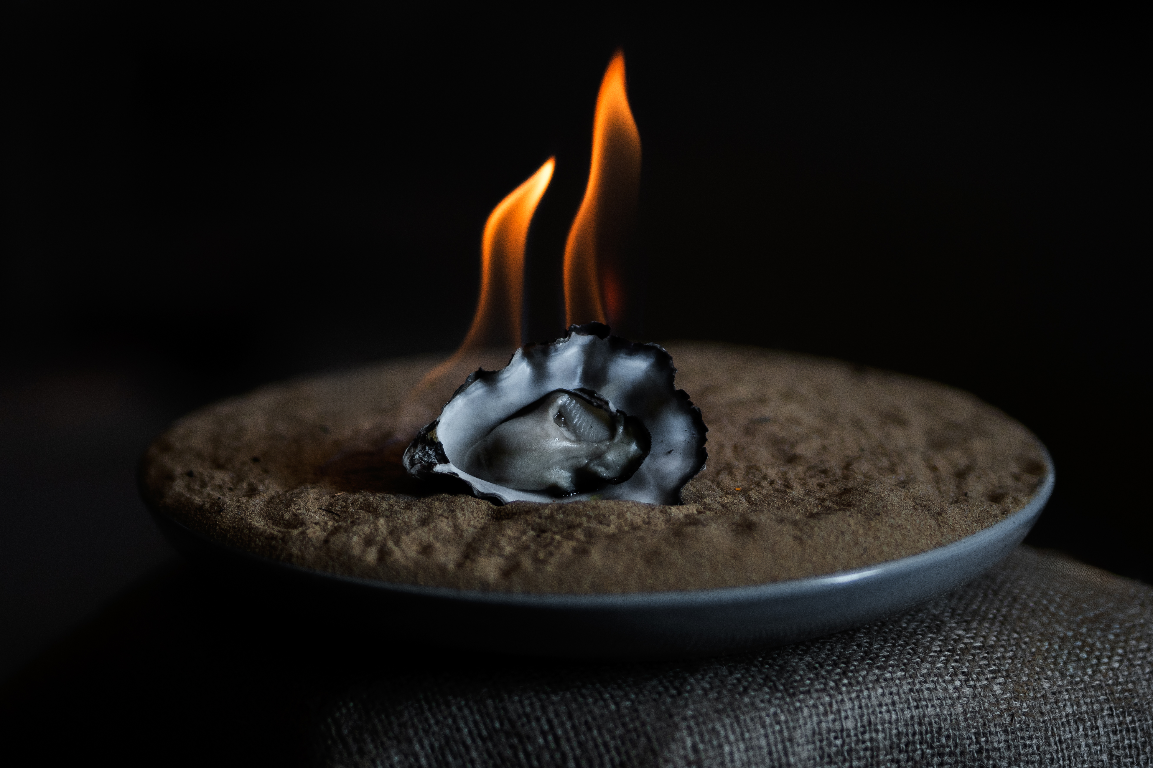 A flaming oyster from Melshell Oyster Shack served on a plate, Dolphin Sands, Tasmania
