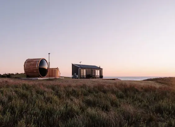 A barrel sauna and small cabin overlooking the sea at Red Rock Hut, King Island, Tasmania
