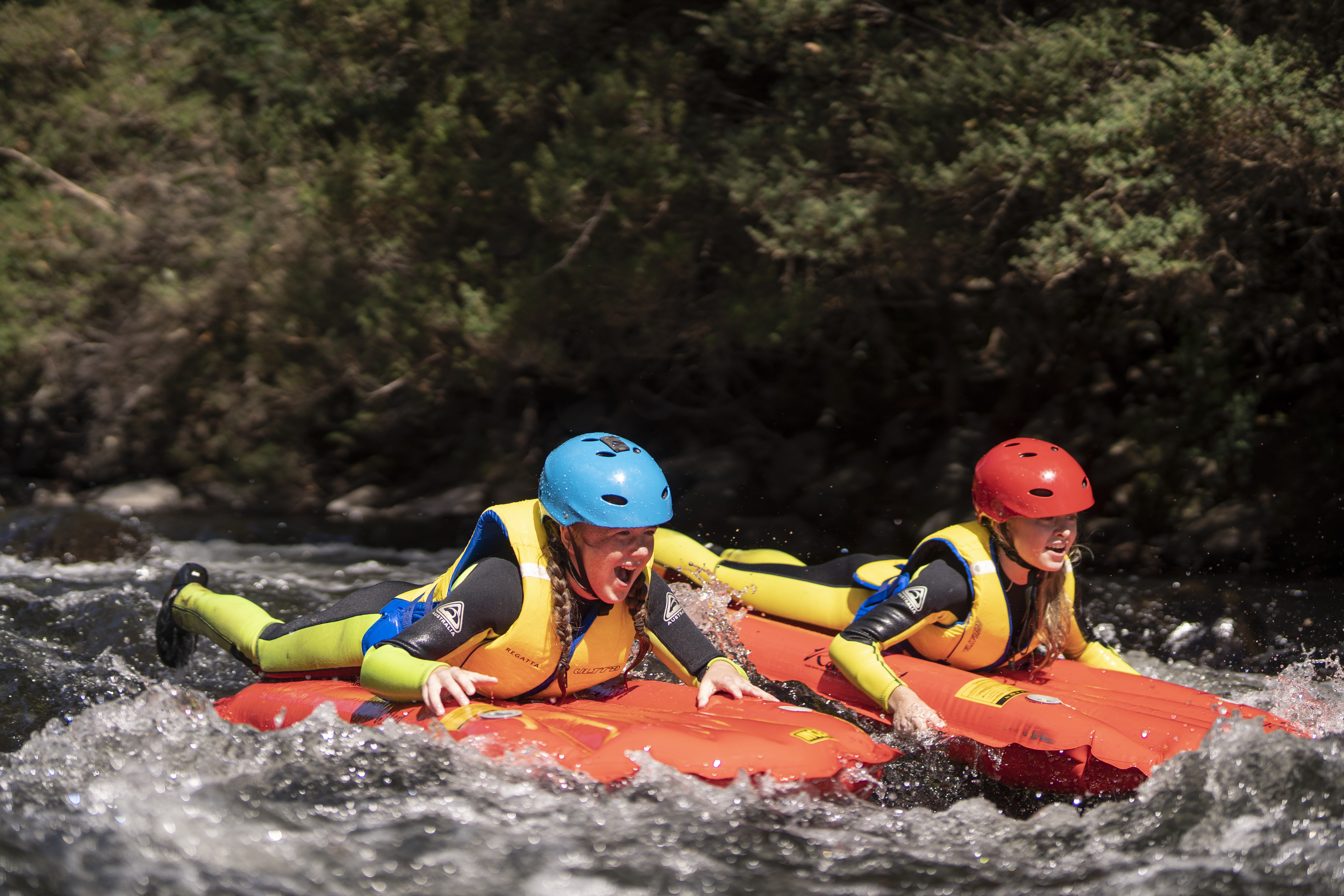 Two people river sledding on a sled through white water rapids on a Meander Wilderness Experience tour, Meander, Tasmania