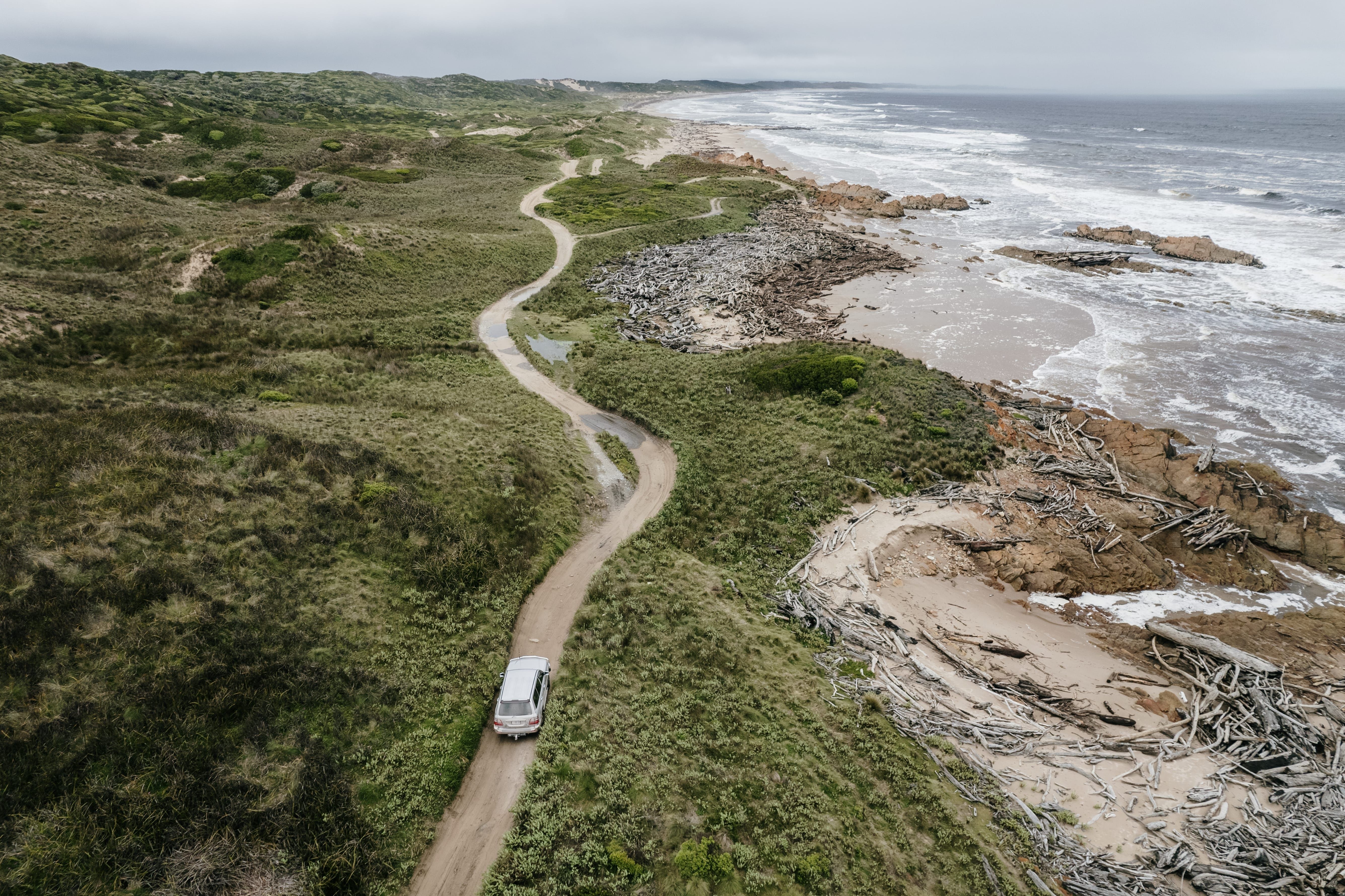 Aerial view of a Tall Timbers 4WD Adventure Tours vehicle on a coastal track, Smithton, takayna / Tarkine, Tasmania