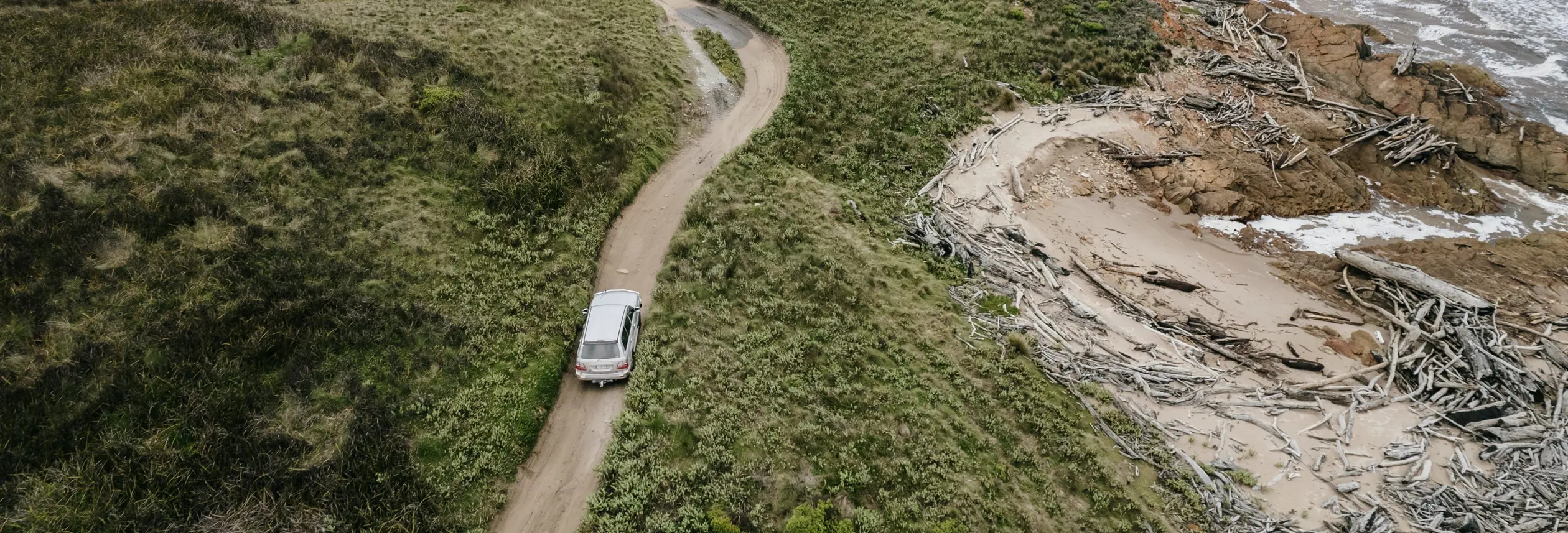 Aerial view of a Tall Timbers 4WD Adventure Tours vehicle on a coastal track, Smithton, takayna / Tarkine, Tasmania