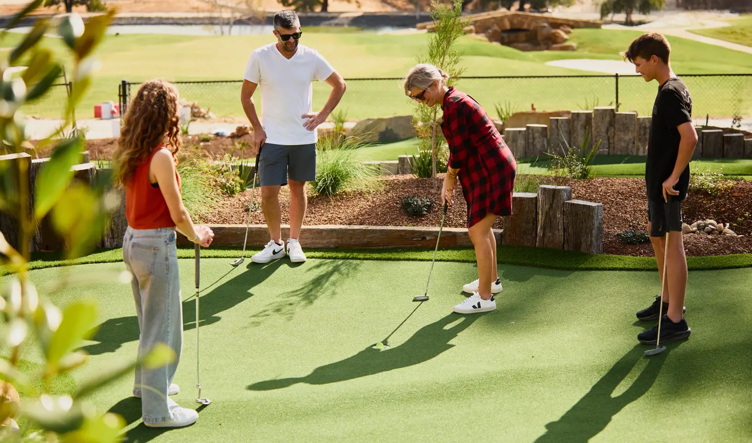 Four people putting on an outdoor mini-golf course at The Range, Country Club Tasmania, Prospect Vale, Tasmania