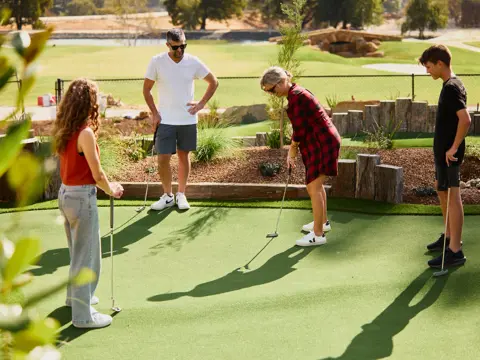 Four people putting on an outdoor mini-golf course at The Range, Country Club Tasmania, Prospect Vale, Tasmania