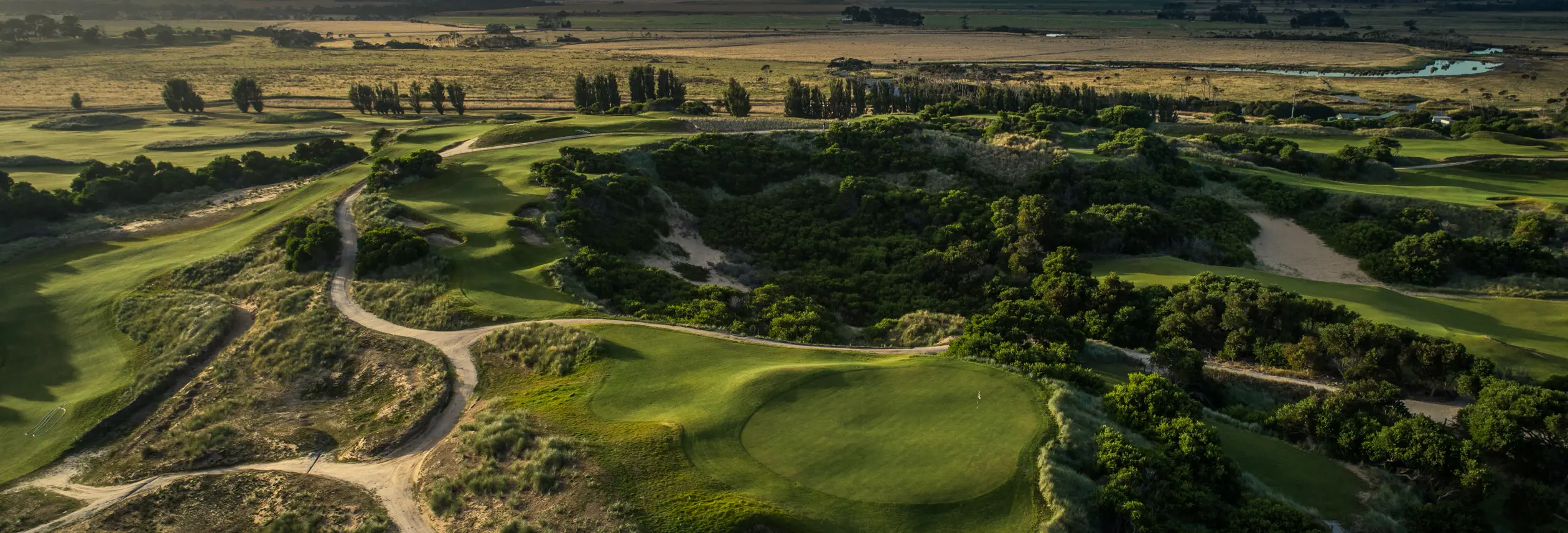 Aerial view of fairways and bunkers winding through coastal dunes at Barnbougle Dunes, Bridport, Tasmania