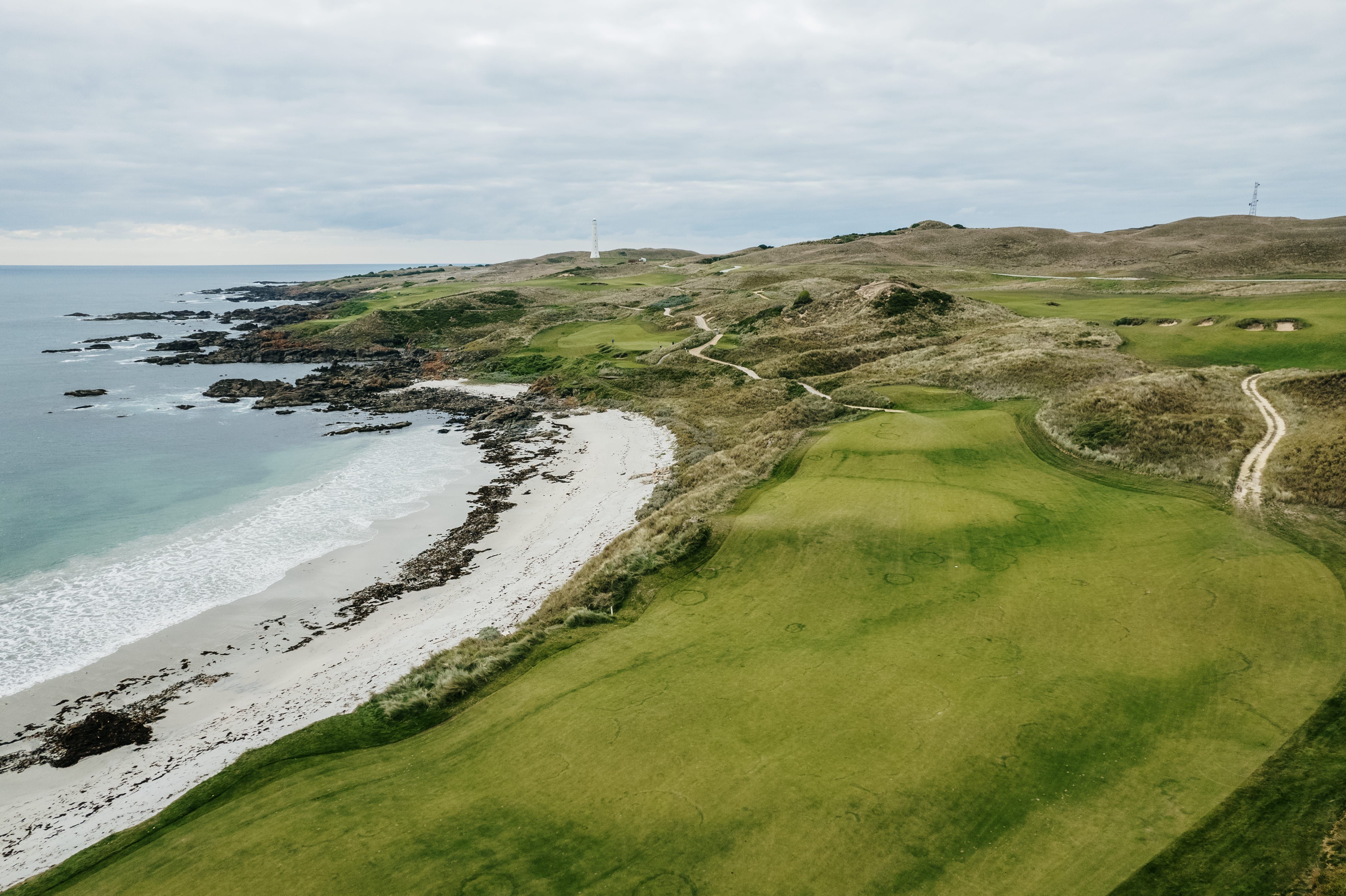 Aerial view of fairways alongside a beach and rugged coastline at Cape Wickham Golf Links, King Island, Tasmania