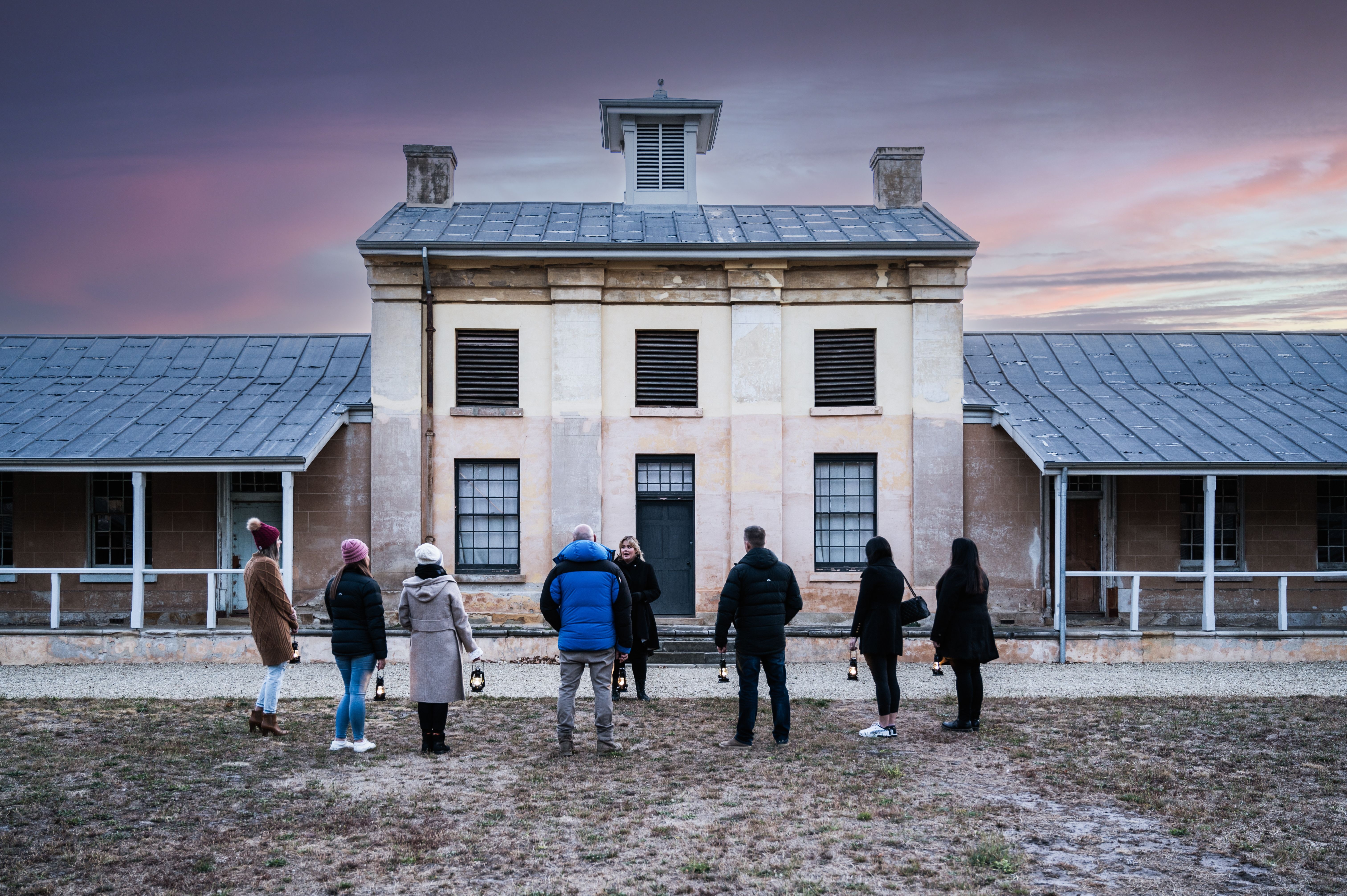 A tour group with lanterns at Willow Court at dusk on a Tasmania's Most Haunted ghost tour, New Norfolk, Tasmania