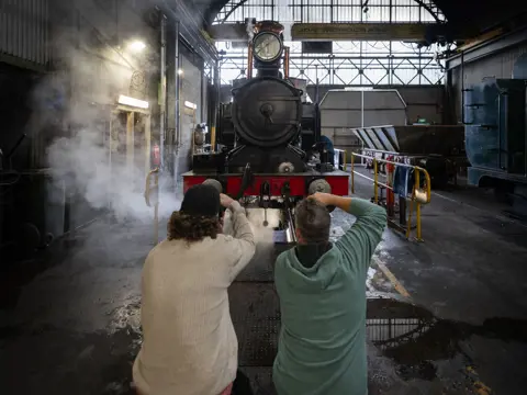 Photographers shooting a steam locomotive on West Coast Wilderness Railway's Steam Under the Stars, Queenstown, Tasmania