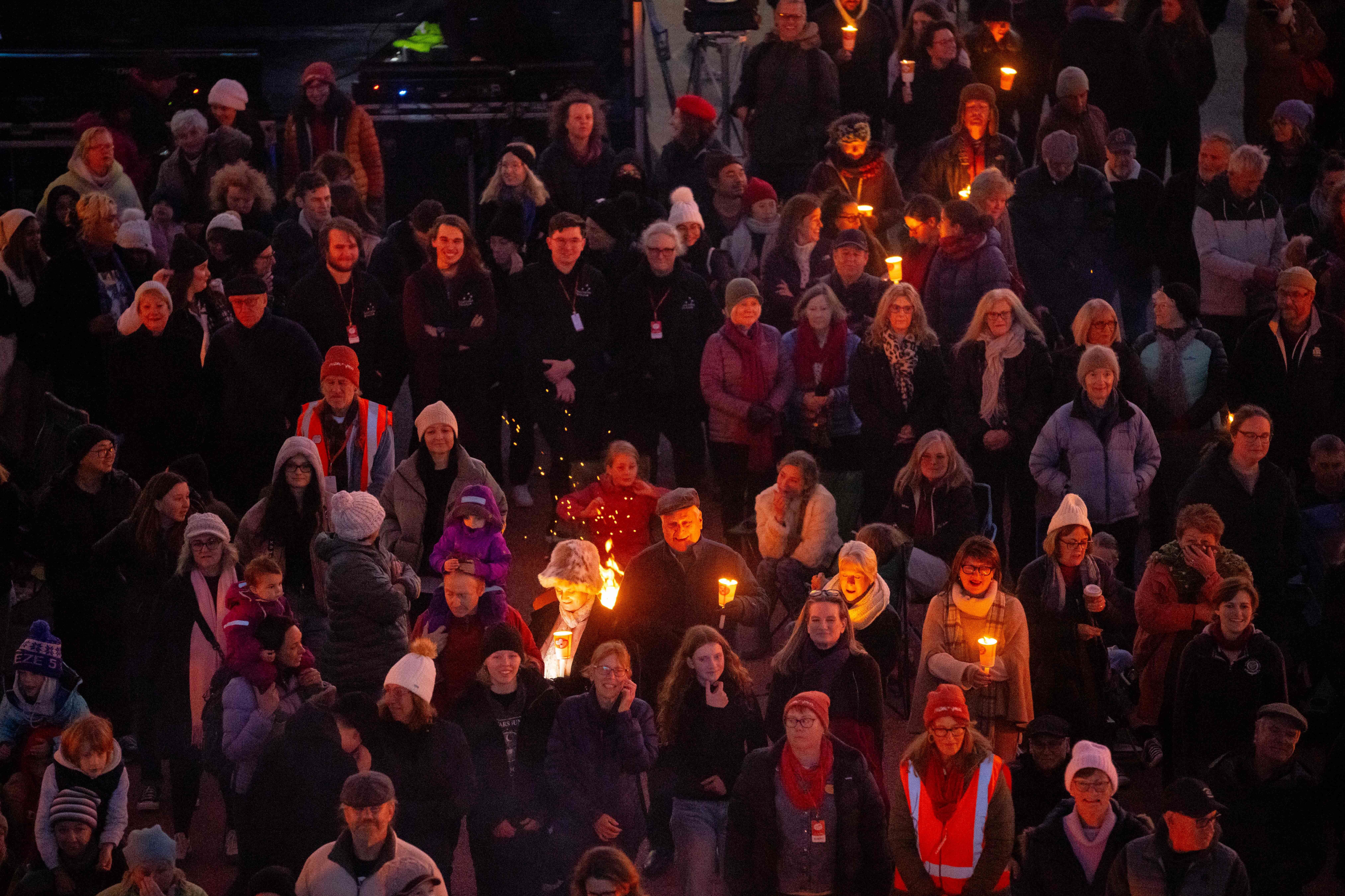 A crowd holding torches and candles at the Big Sing Bonfire during Festival of Voices, Hobart, Tasmania