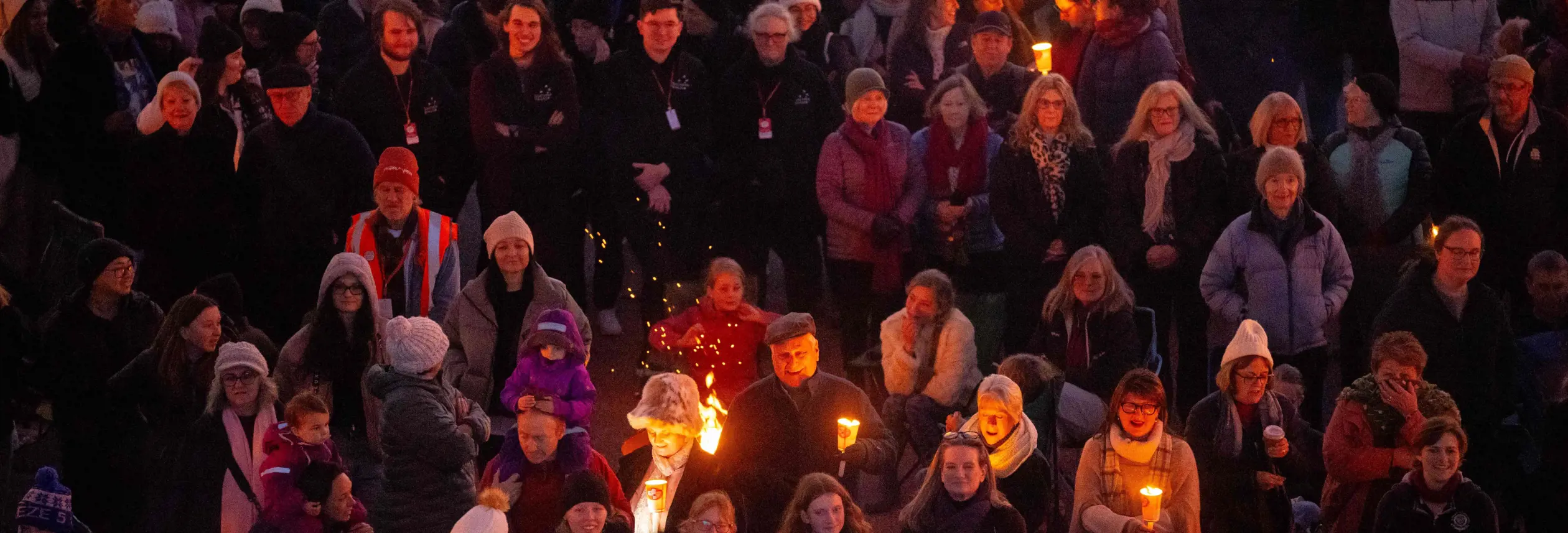 A crowd holding torches and candles at the Big Sing Bonfire during Festival of Voices, Hobart, Tasmania