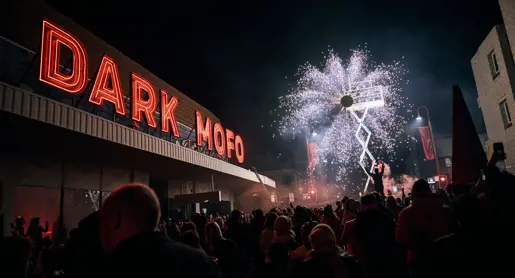 A crowd watching pyrotechnics under the red Dark Mofo neon sign at Night Mass: God Complex during Dark Mofo, Hobart, Tasmania