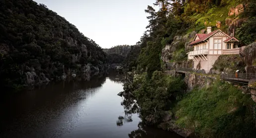 A heritage cottage on a rocky ledge above the river at Cataract Gorge Reserve, Launceston, Tasmania