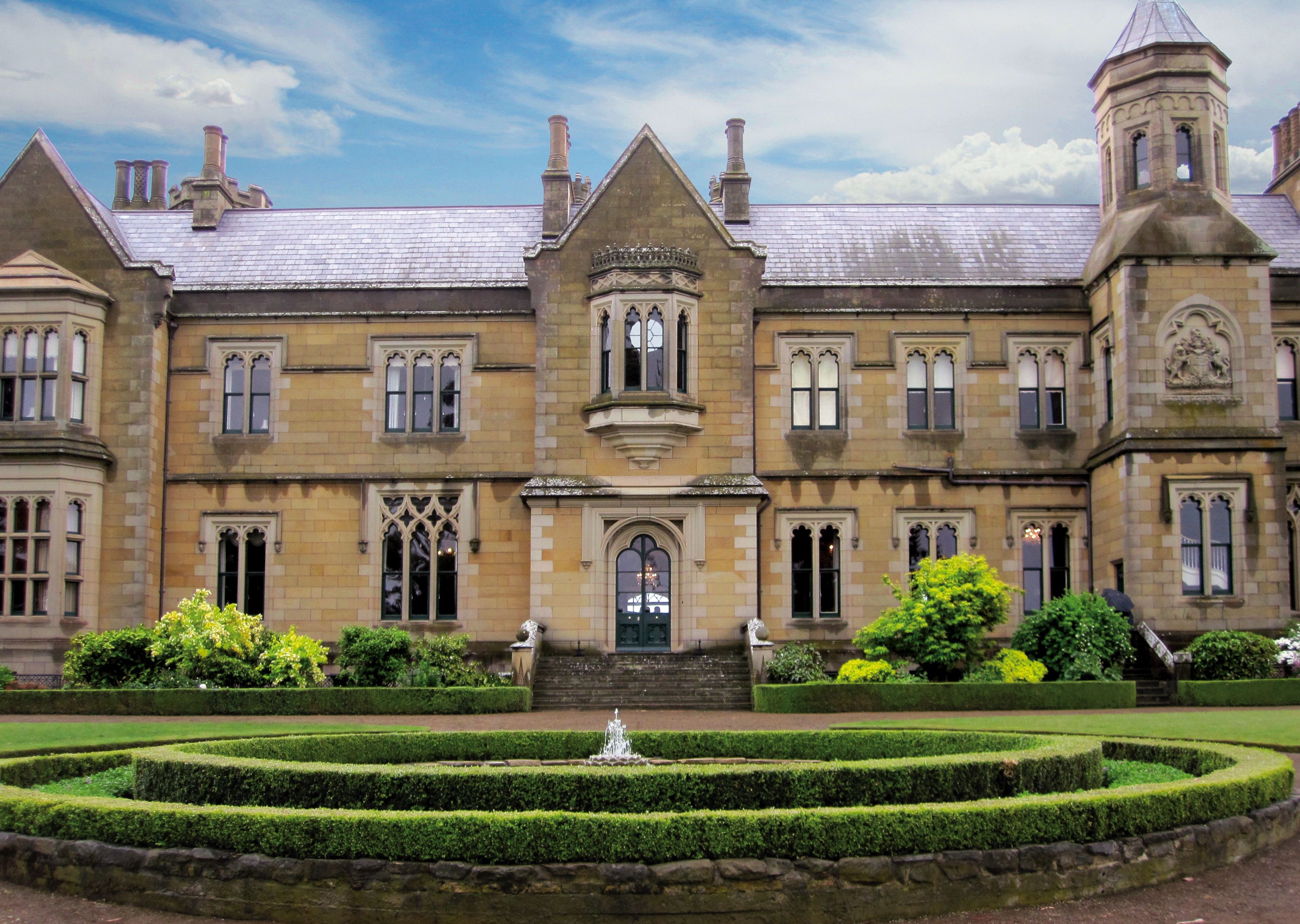 Government House heritage building with circular hedge garden and fountain in the foreground, Hobart, Tasmania