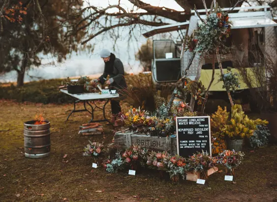 A stallholder preparing winter wreaths and posy jars at Festival of Voices Farmers Market, Twamley Farm, Buckland, Tasmania