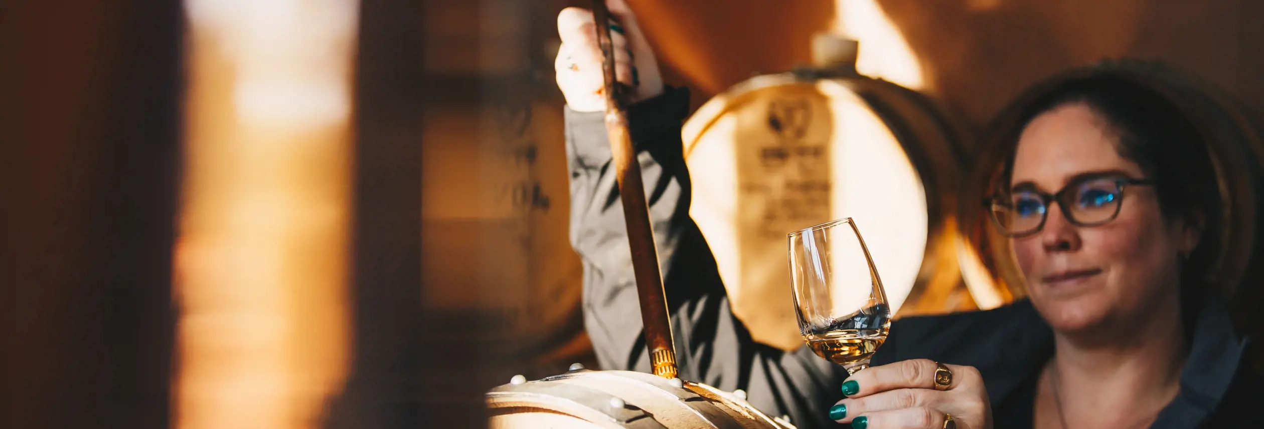 A distiller drawing whisky from a barrel at Killara Distillery, Richmond