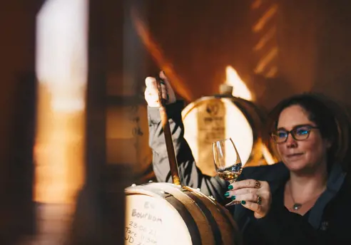 A distiller drawing whisky from a barrel at Killara Distillery, Richmond