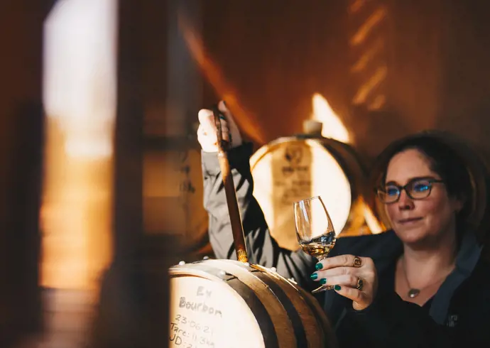 A distiller drawing whisky from a barrel at Killara Distillery, Richmond