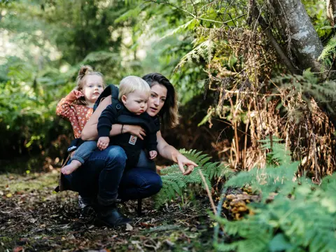 A mother and two young children exploring flora in Leven Park on a Leven River Cruises tour, Ulverstone