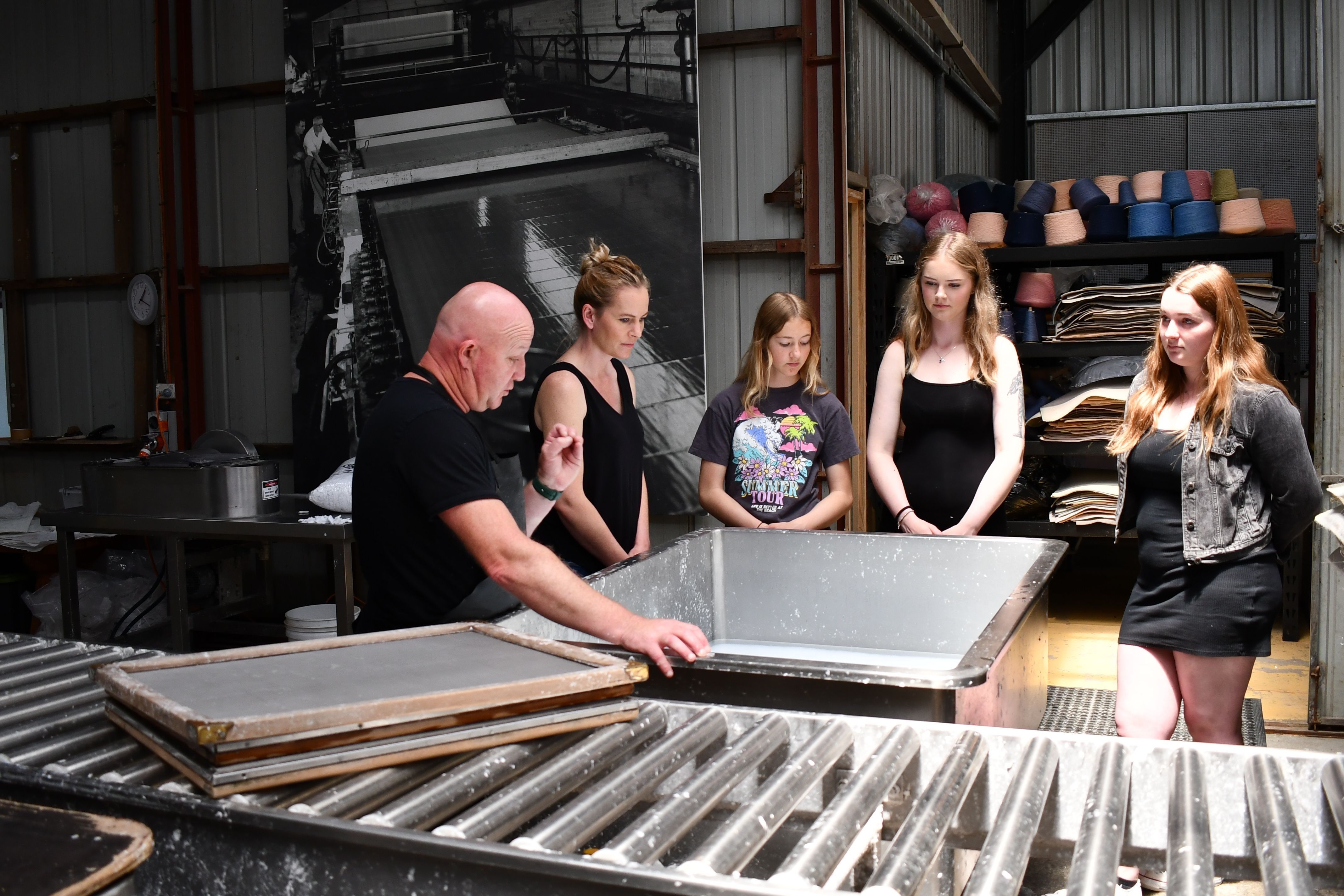 A papermaker demonstrating handmade paper-making to visitors at Creative Paper Tasmania, Wynyard