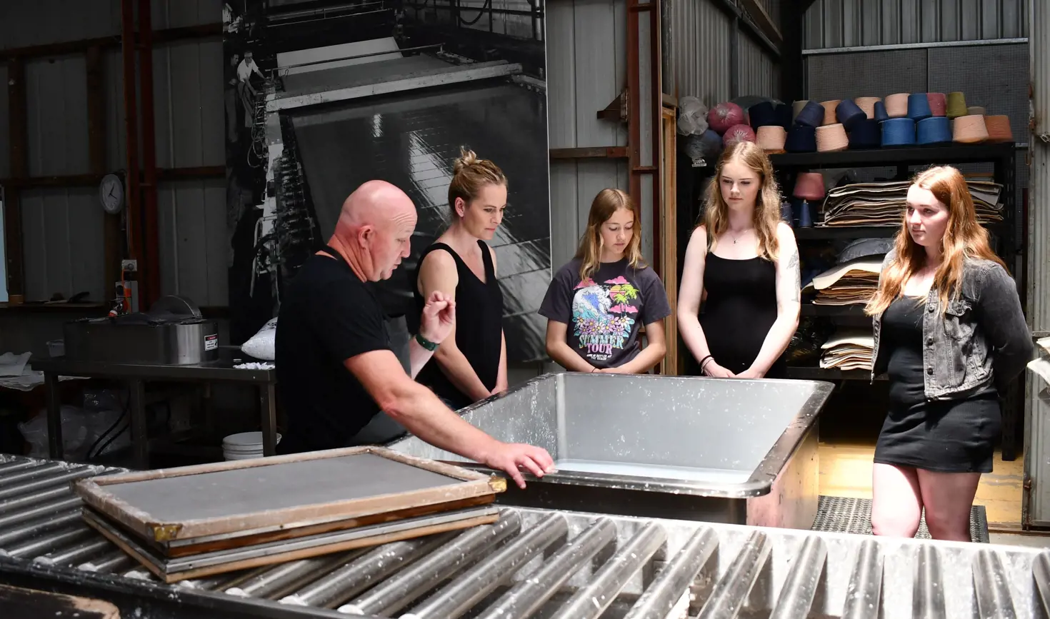 A papermaker demonstrating handmade paper-making to visitors at Creative Paper Tasmania, Wynyard