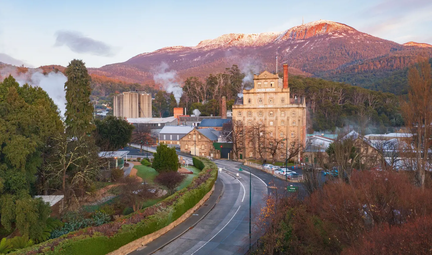 Cascade Brewery's heritage sandstone building beneath snow-dusted kunanyi / Mount Wellington, South Hobart