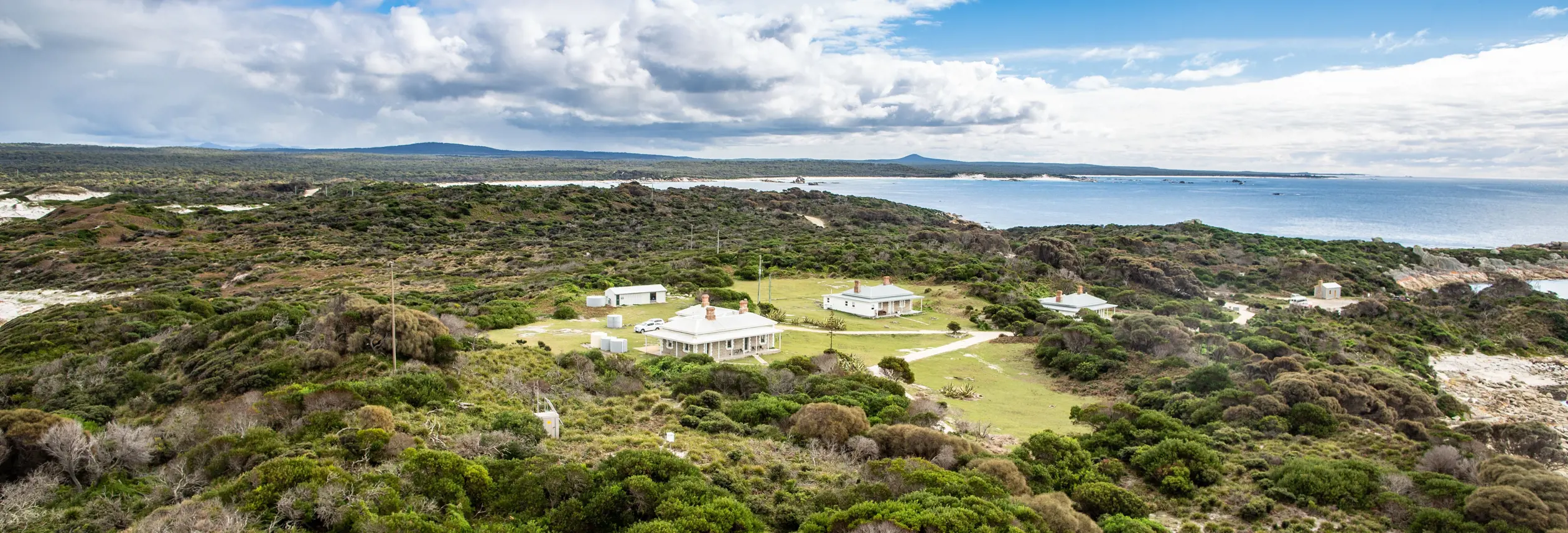 Aerial view of the heritage lightkeepers cottages used by wukalina Walk at Eddystone Point, larapuna / Bay of Fires area