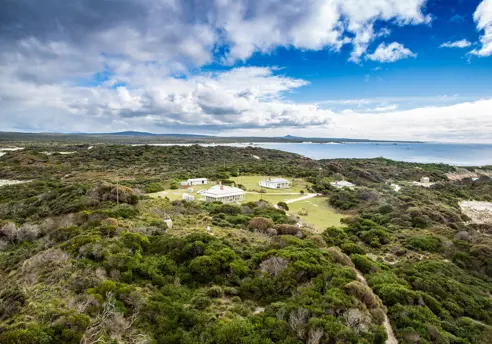 Aerial view of the heritage lightkeepers cottages used by wukalina Walk at Eddystone Point, larapuna / Bay of Fires area