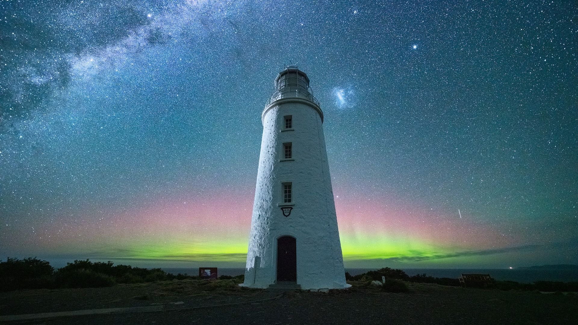 Aurora Australis glowing green and pink behind Cape Bruny Lighthouse beneath the Milky Way, Bruny Island