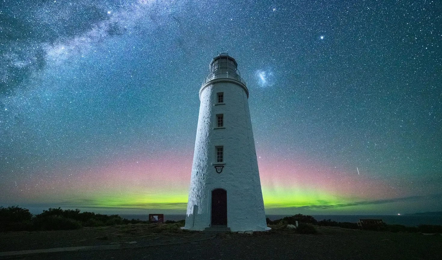Aurora Australis glowing green and pink behind Cape Bruny Lighthouse beneath the Milky Way, Bruny Island