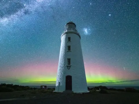 Aurora Australis glowing green and pink behind Cape Bruny Lighthouse beneath the Milky Way, Bruny Island