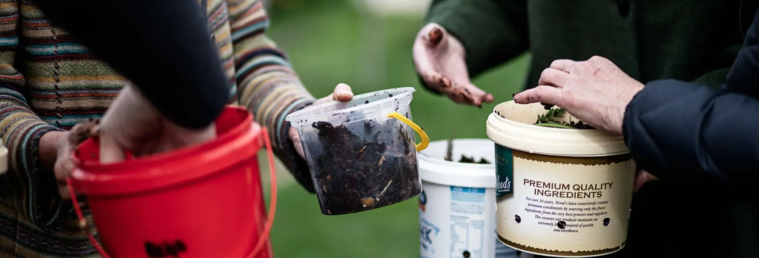 Close-up of people holding buckets of compost and soil at the AgriCULTURED Northern Suburbs Community Garden in Launceston