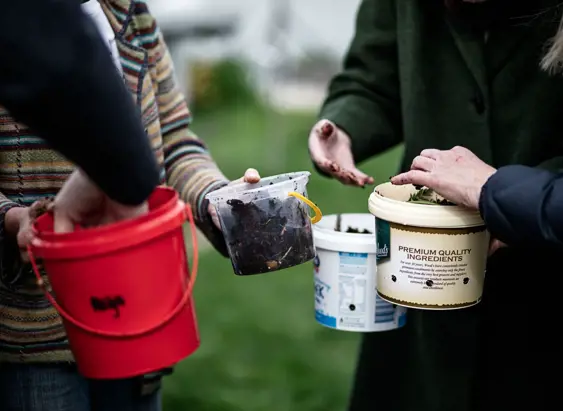 Close-up of people holding buckets of compost and soil at the AgriCULTURED Northern Suburbs Community Garden in Launceston