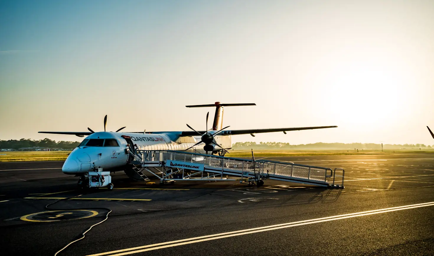 A QantasLink regional aircraft with airstairs deployed on the tarmac at Launceston Airport