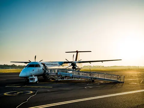 A QantasLink regional aircraft with airstairs deployed on the tarmac at Launceston Airport