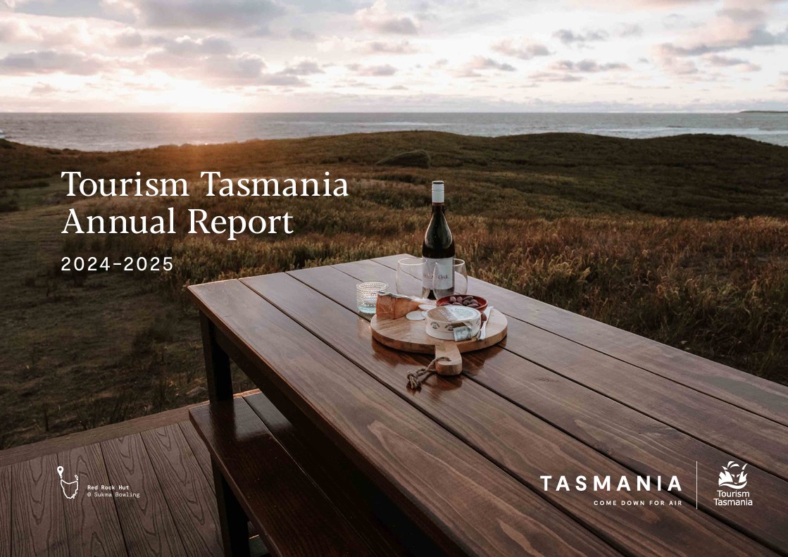 Cover of Tourism Tasmania's Annual Report 2024-2025, with wine and platter at Red Rock Hut, King Island