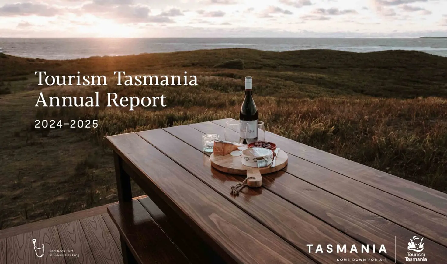 Cover of Tourism Tasmania's Annual Report 2024-2025, with wine and platter at Red Rock Hut, King Island