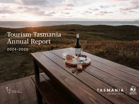 Cover of Tourism Tasmania's Annual Report 2024-2025, with wine and platter at Red Rock Hut, King Island