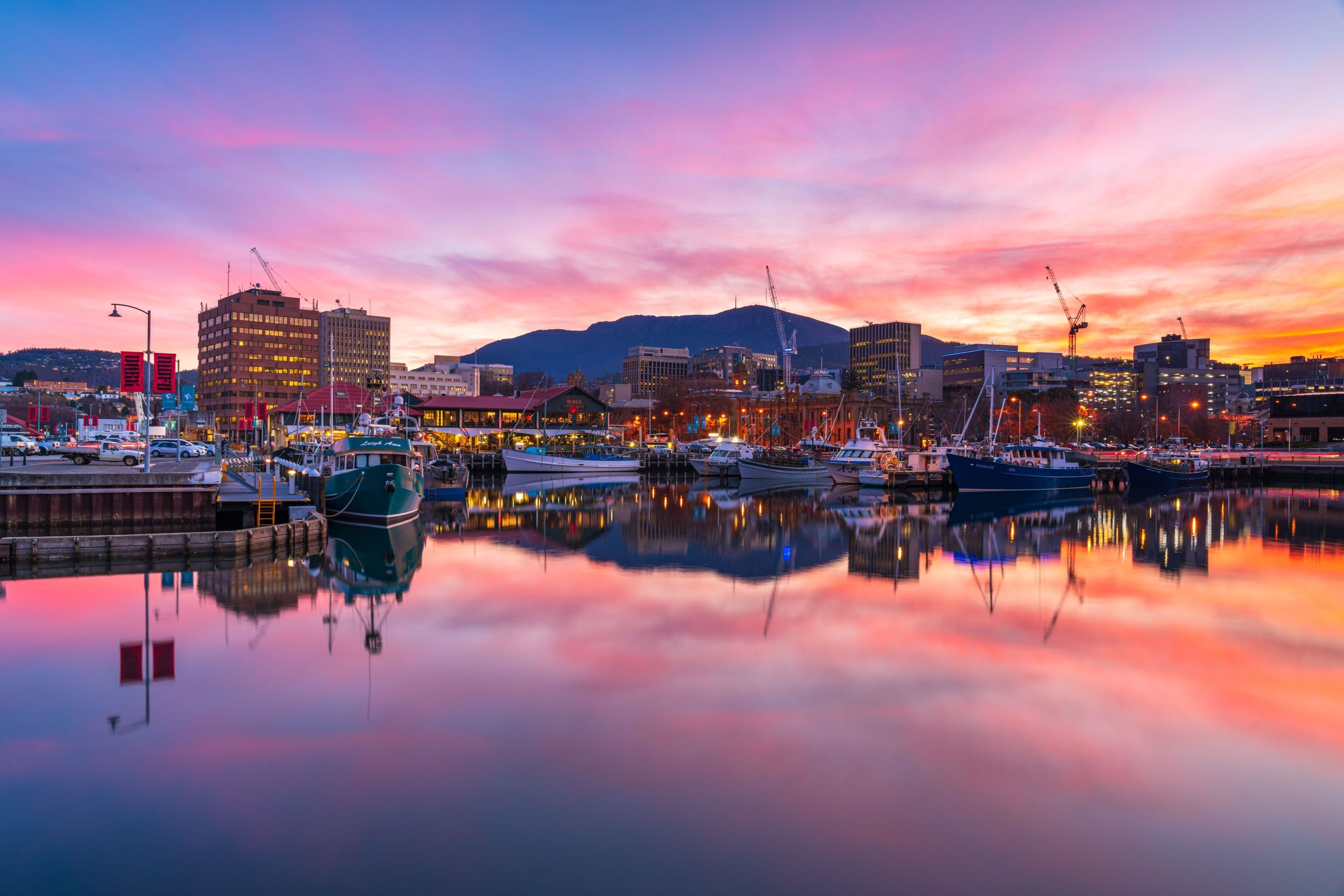 Boats moored at Hobart waterfront at sunset with kunanyi / Mount Wellington in the distance
