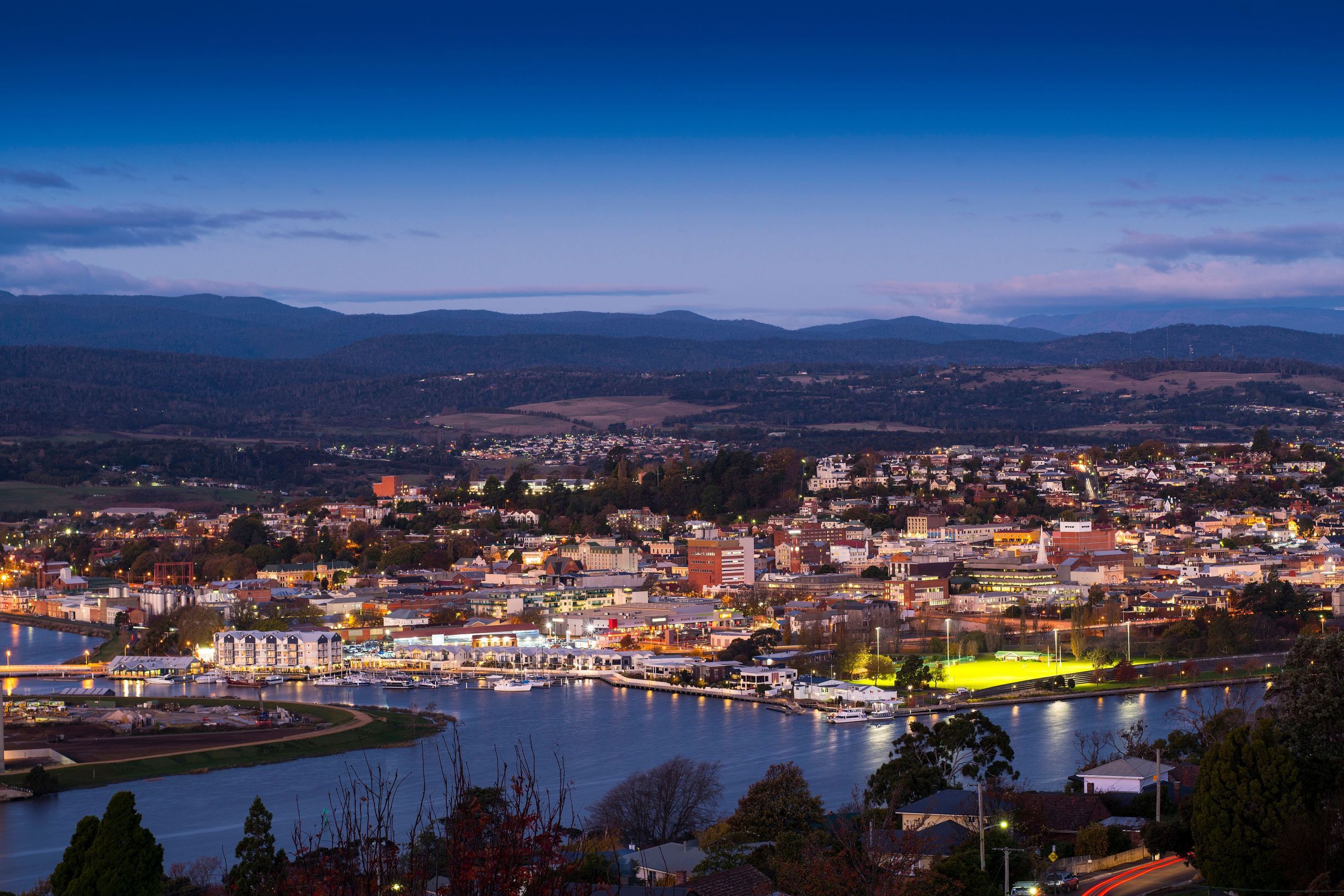 Elevated view of Launceston city lights and the kanamaluka / River Tamar at twilight, northern Tasmania