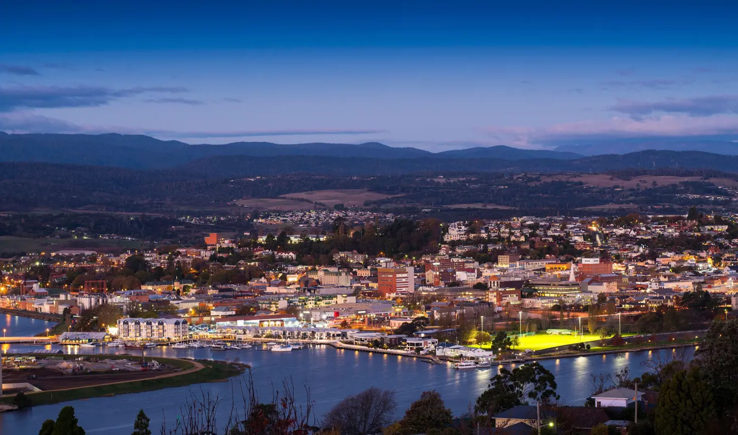 Elevated view of Launceston city lights and the kanamaluka / River Tamar at twilight, northern Tasmania